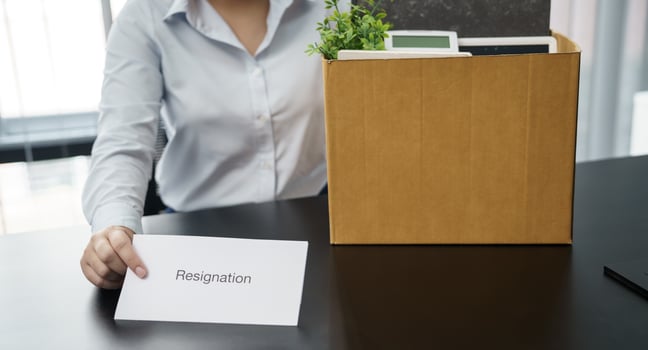 Business woman sending resignation letter to boss and Holding Stuff Resign Depress or carrying cardboard box by desk in office photo