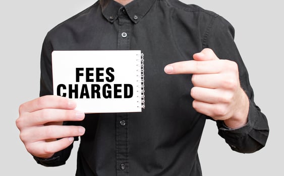 Businessman holding a white notepad with text FEES CHARGED, business concept photo