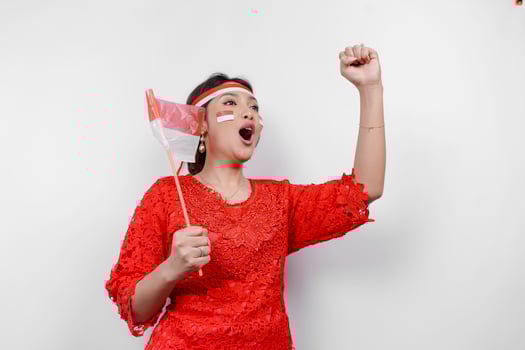 A young Asian woman with a happy successful expression wearing red kebaya and headband isolated by white background. Indonesia's independence day concept. photo