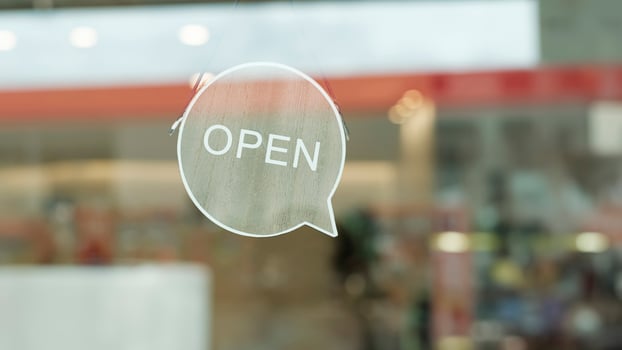 We are open sign hanging on the entrance door of a small cafe. photo