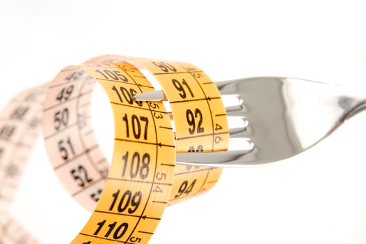 a fork and knife surrounded by measuring tape photo