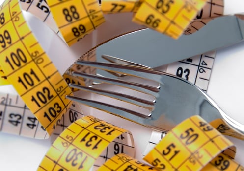 a fork and knife surrounded by measuring tape photo