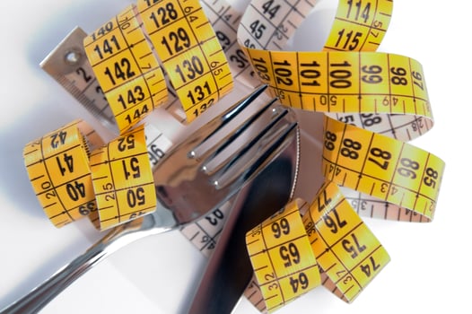 a fork and knife surrounded by measuring tape photo