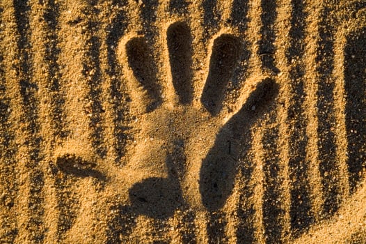 a hand print in the sand with two hands photo