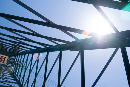 the sun shines through the metal structure of an oil rig photo