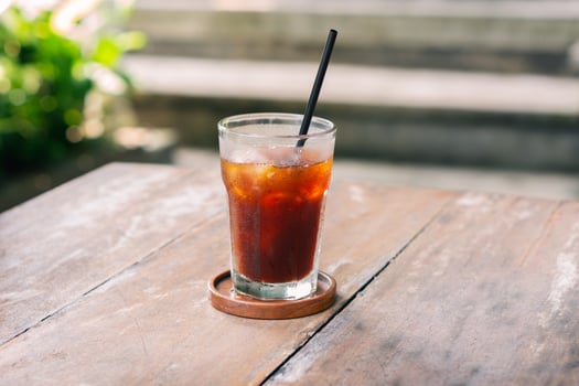 transparent glass of ice black coffee or americano on wooden table with selective focus in cafe restaurant photo