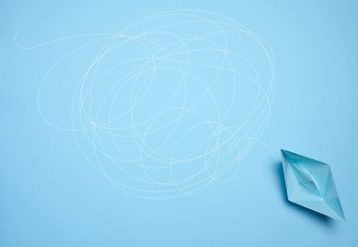 A blue paper boat and a long tangled path, symbolizing the concept of a challenging journey photo