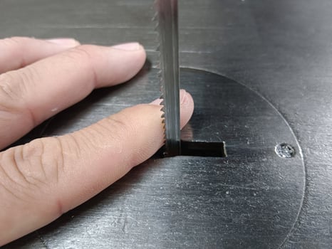Hand holding the saw blade sharp and dangerous photo