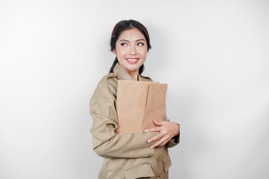 A Young beautiful Asian worker with brown uniform bringing document. Indonesian PNS. photo