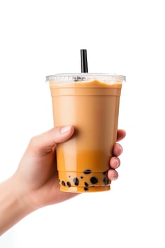 A hand holding takeaway plastic cup of delicious iced bubble milk tea and black pearls isolated on white background. ai generated photo