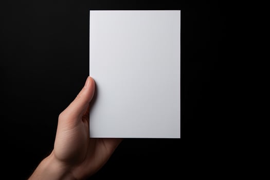 A human hand holding a blank sheet of white paper or card isolated on black background. ai generated photo