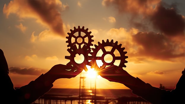 Teamwork concept represented by hands holding gear against a sunny backdrop photo