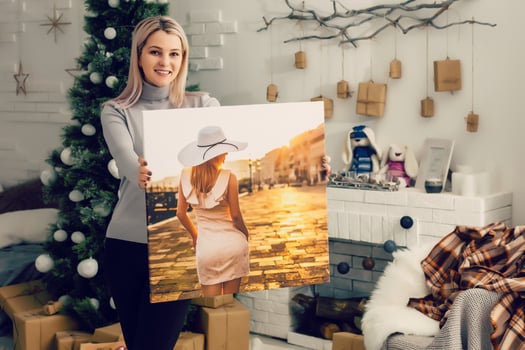 girl holds photo canvas at home on the couch