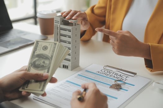 Real estate brokerage agent Deliver a sample of a model house to the customer, mortgage loan agreement Making lease and buy and sell house And contract home insurance mortgage loan concept photo