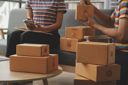 Young woman small business owner online shopping at home. taking note of orders from customers with mobile phones. SME entrepreneur or freelance life style concept. photo