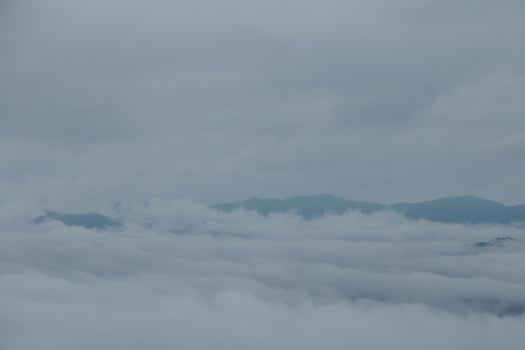 Mountain range with visible silhouettes through the morning blue fog. photo