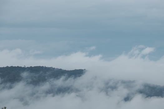 Mountain range with visible silhouettes through the morning blue fog. photo