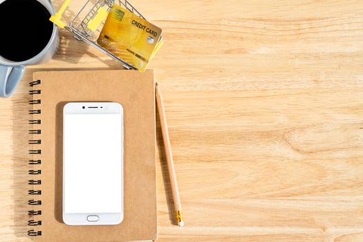 Credit cards,notebook,flower pot tree,smartphone,Shopping cart and coffee cup on wooden background,Online banking Concept,Top view office table. photo