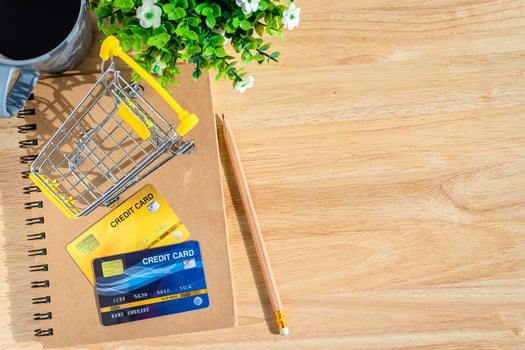 Credit cards,notebook,flower pot tree,Shopping cart and coffee cup on wooden background,Online banking Concept,Top view office table. photo