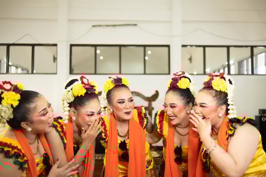 a group of traditional Javanese dancers laughing together with ridiculous faces and full of joy while on stage photo
