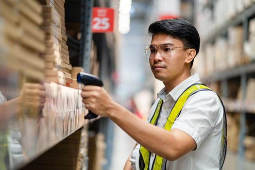 Male warehouse worker scanning barcodes on boxes in a warehouse. Male warehouse worker working with barcode scanner. photo