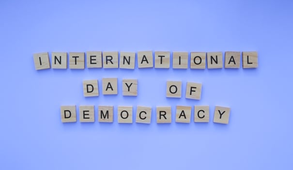 September 15, International Day of Democracy, minimalistic banner with the inscription in wooden letters on a blue background photo