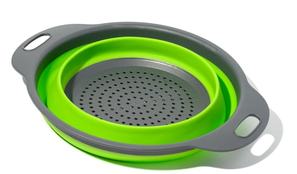 Plastic green collapsible colander on white isolated background photo