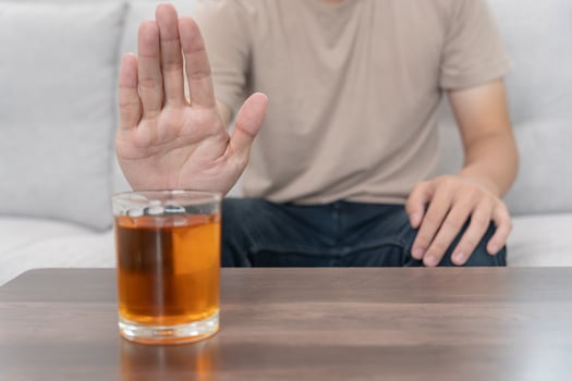 man refuses say no and avoid to drink an alcohol whiskey , stopping hand sign male, alcoholism treatment, alcohol addiction, quit booze, Stop Drinking Alcohol. Refuse Glass liquor, unhealthy, reject photo