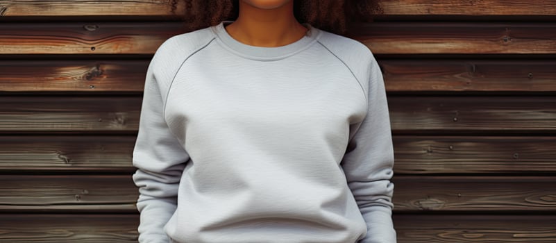 African American woman in grey sweatshirt by wooden fence space for text Fashionable casual wear untouched photo