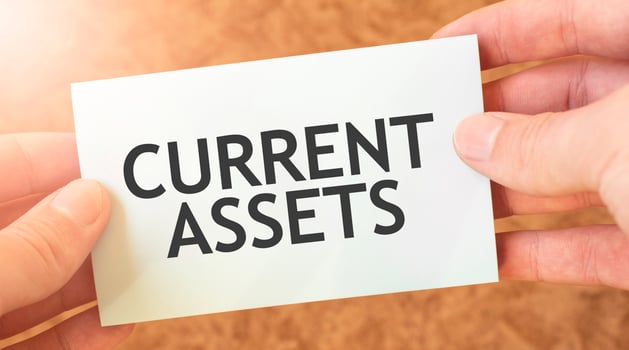 CURRENT ASSETS word inscription on white card paper sheet in hands of a businessman. recap concept. red and white paper photo