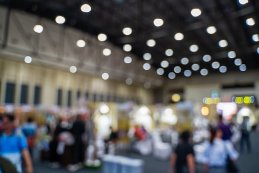 Blurred images of trade fairs in the big hall. image of people walking on a trade fair exhibition or expo where business people show innovation activity and present products in a big hall. photo