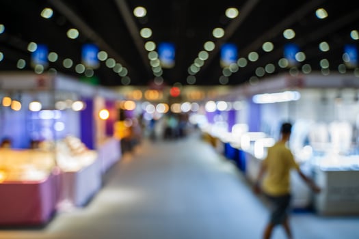 Blurred images of trade fairs in the big hall. image of people walking on a trade fair exhibition or expo where business people show innovation activity and present products in a big hall. photo