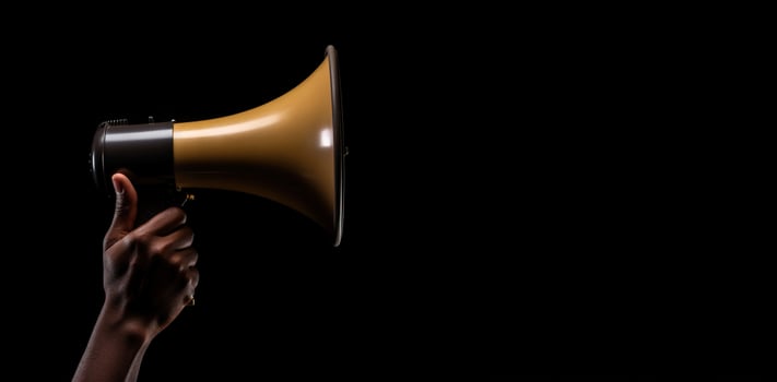 Generative AI, golden megaphone in hand on a empty black background, panoramic image with copy space photo