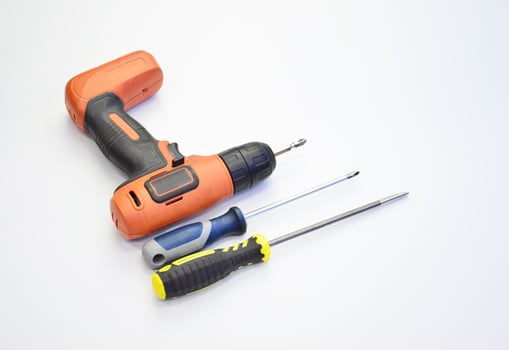 Electric screwdriver and hand screwdriver set on white background photo