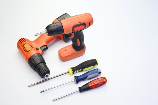 Electric screwdriver and hand screwdriver set on white background photo