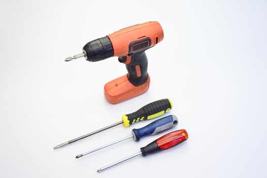 Electric screwdriver and hand screwdriver set on white background photo