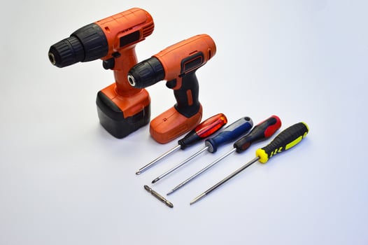 Electric screwdriver and hand screwdriver set on white background photo