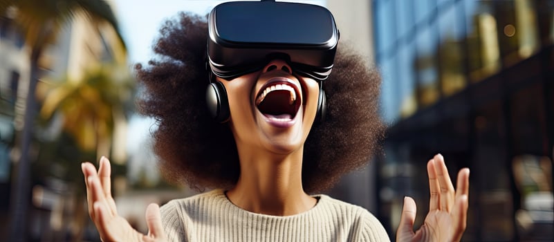Happy African American woman in a dress using VR glasses and controlling space with her hands enjoys game and explores city Online app gadget virtual real photo