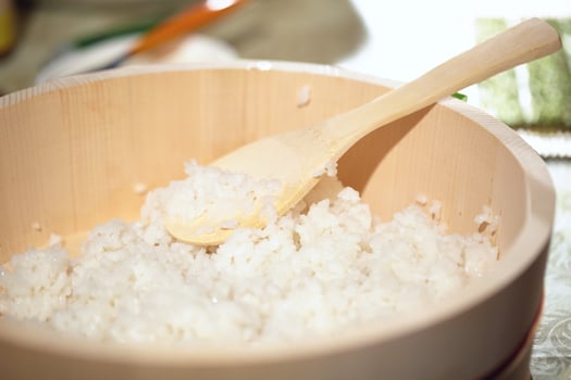 Cooking sushi. Mixing rice in a wooden plate. photo