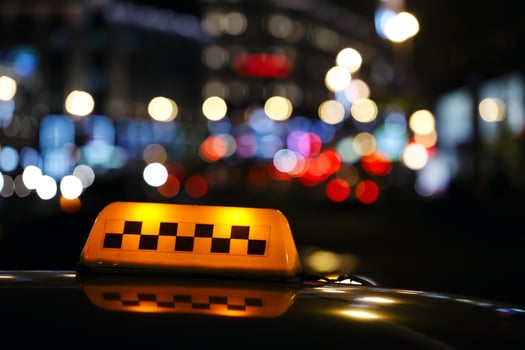Illuminated taxi cab sign on a city street photo