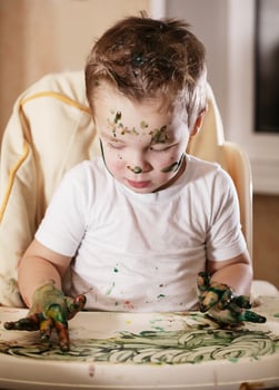 Creative little boy playing with finger paint photo