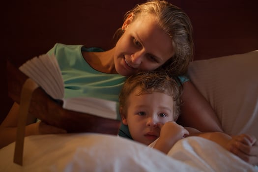Mother reading a bedtime story to her little son photo