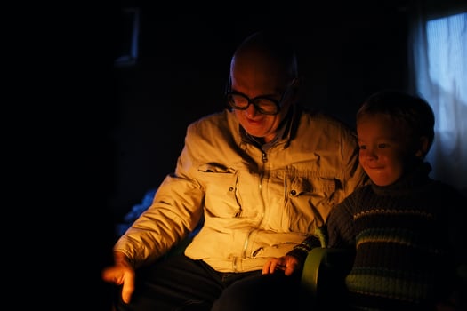 Grandfather and grandson near fire at home. photo