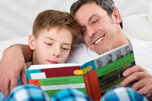 Son and father reading book together photo
