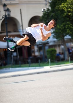 Young man performing somersault in the street photo