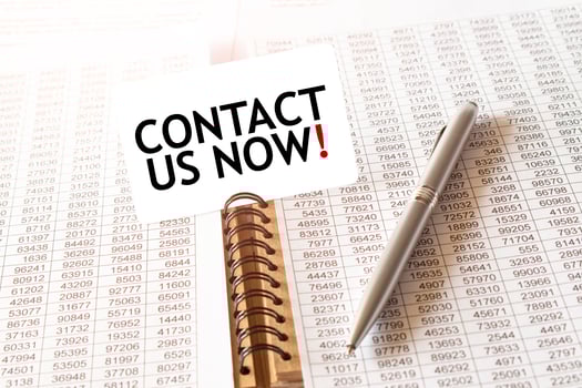 Text CONTACT US NOW on paper card, pen, financial documentation on table photo