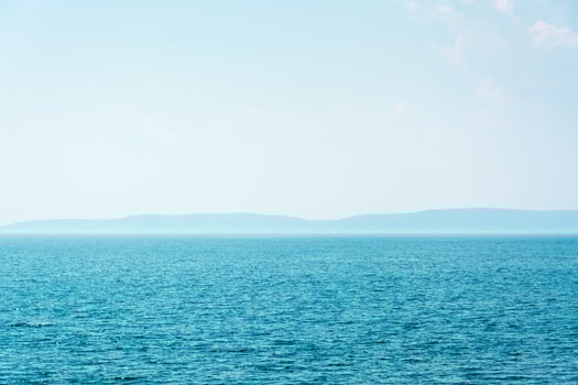 Bay of blue sea and mountains on the horizon. Local tourism photo