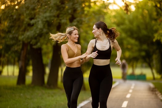 Two pretty young women running on the lane in the park photo