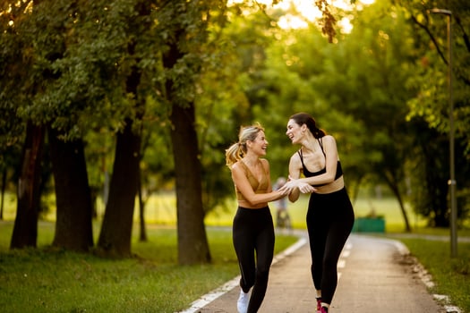 Two pretty young women running on the lane in the park photo