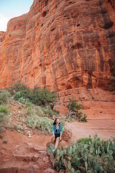 Young hiker woman on the edge of a cliff at Cathedral Rock in Sedona, Arizona. View from Scenic Cathedral Rock in Sedona with blue sky in Arizona photo